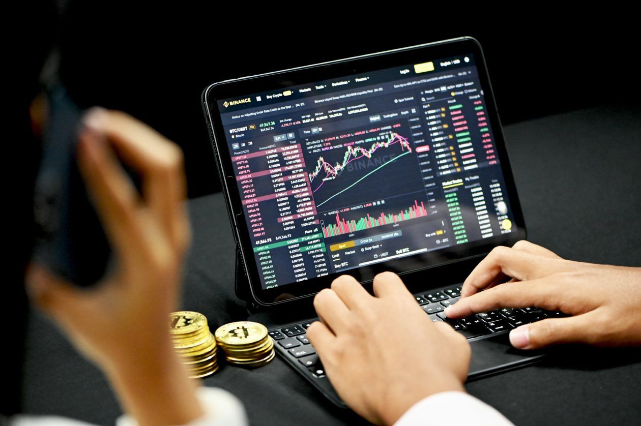 Crypto coins beside a trading laptop